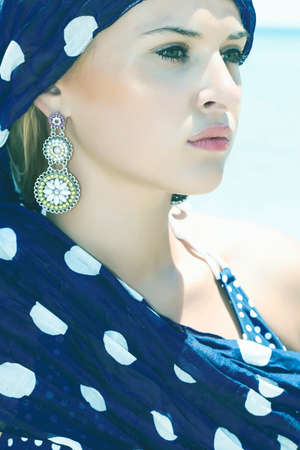 beautiful woman in a blue shawl on the beachの写真素材