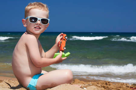 Child in sunglasses on the beach  little boy near the seaの写真素材