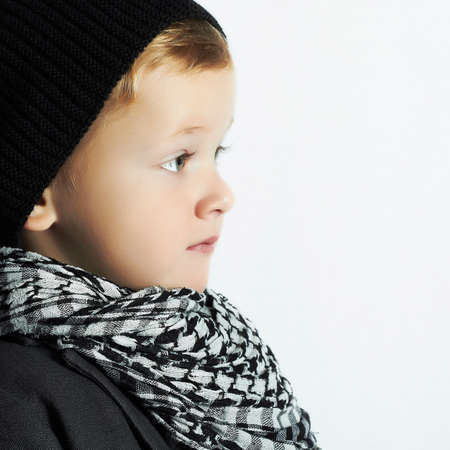 fashionable little boy in scarf and hat.stylish kid. fashion children. black cap. winter styleの写真素材