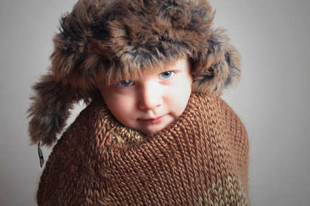 frozen child in fur Hat.fashion winter style.little boy.children.coldの写真素材
