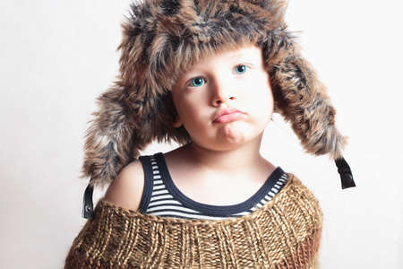 child in fur hat. fashion funny kid. winter style. little boy. childrenの写真素材