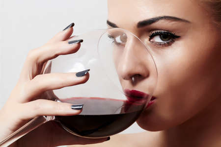 Beautiful blond woman drinking red wineの写真素材