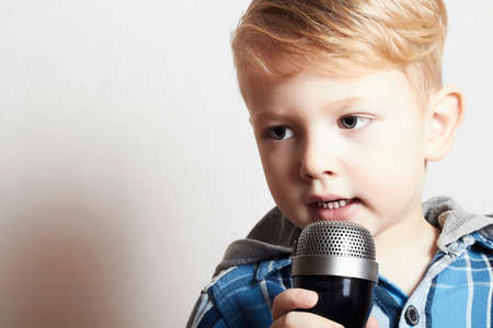 little boy singing with microphoneの写真素材