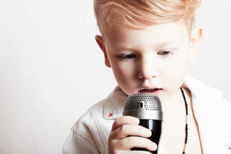 little boy singing with microphoneの写真素材