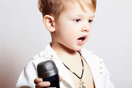 little boy singing with microphoneの写真素材