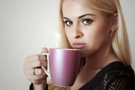 Beautiful blond woman drinking Coffee. Cup of tea. Hot drinkの写真素材