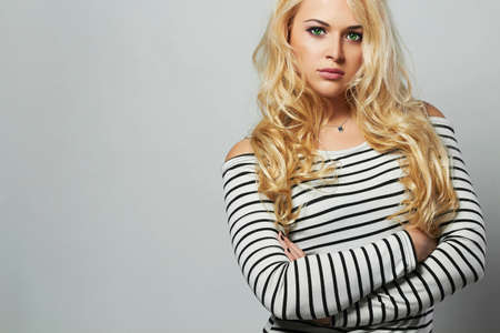 Beautiful woman in sailor dress. Curly hair. Beauty Posing Fashion Blond Girlの写真素材