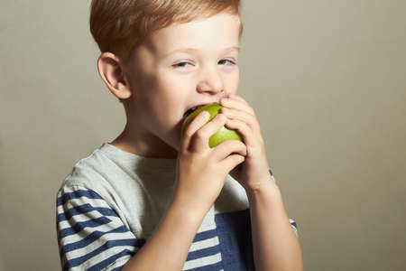 Funny Child eating apple.Little Boy. Health food. Fruits.Vitamin Cの写真素材