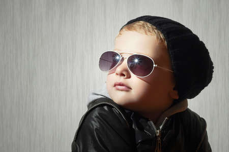 Fashionable little boy in sunglasses. Child in Black cap. Winter style.Kids fashionの写真素材