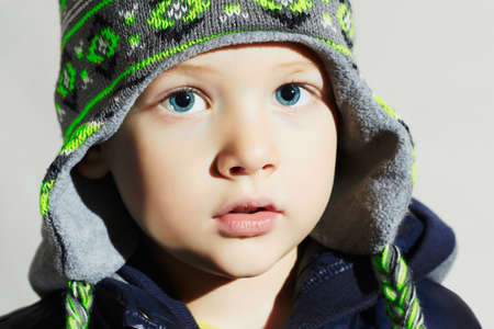 child with blue eyes.fashion kids.fashionable little boy in winter capの写真素材