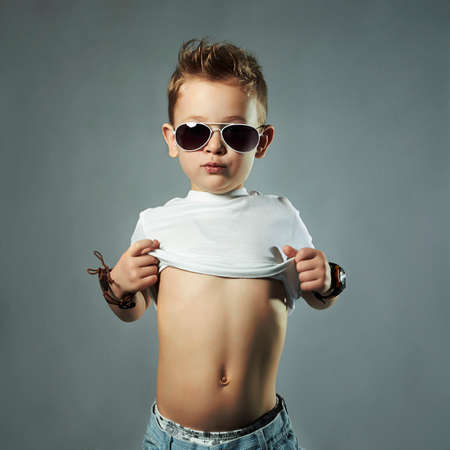 fashionable little boy in sunglasses.funny child show belly. children emotion. belly dancerの写真素材