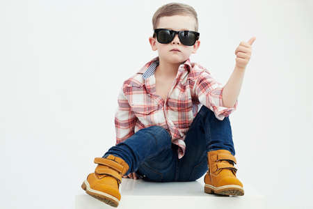 Funny child.fashionable little boy in sunglasses.stylish kid in yellow shoes