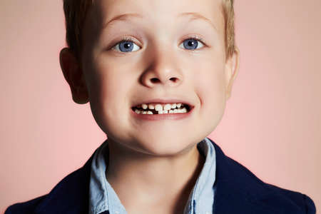 little boy showing that he lost first milk tooth.child with missing front toothの写真素材