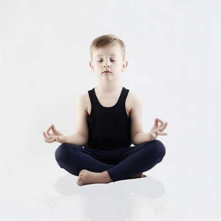 Relaxed child does yoga.handsome little Boyの写真素材