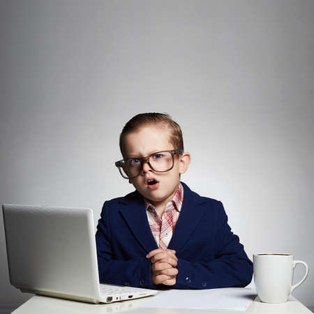 Young business boy. funny child in glasses. little boss in officeの写真素材