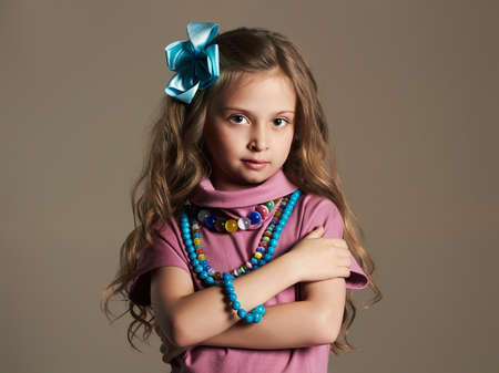 fashionable beautiful little girl.pretty little lady in dress and flower in healthy hairの写真素材
