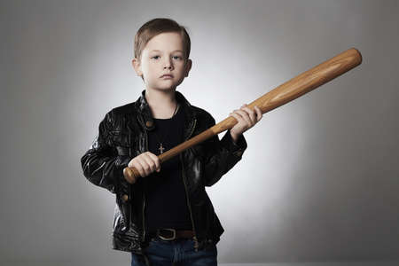 criminal boy with baseball bat.Funny child in leather coat.little thug
