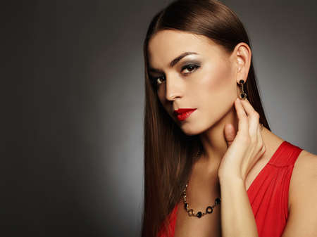 fashion portrait of young beautiful sexy woman.Beauty brunette girl with make-up.elegant lady in red dressの写真素材