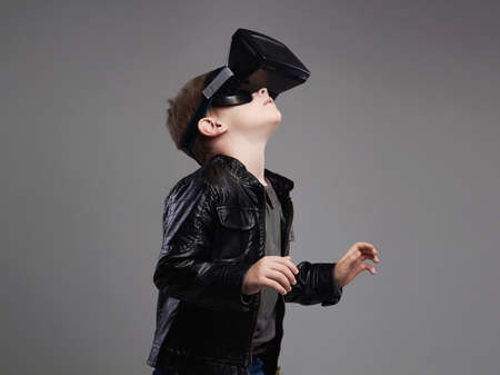 little Boy in virtual reality glasses playing the game. 3D gadget technology. VR glasses cardboardの写真素材