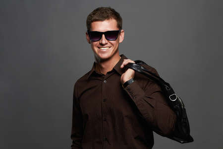 young man with a handbag. Handsome man in sunglassesの写真素材
