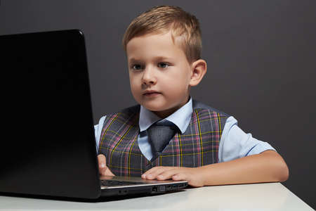 boy looking in the notebook screen. funny child with computerの写真素材