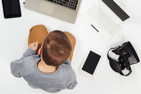 fashionable child with computers, tablets, phones, gadgets around. little boy and new technologyの写真素材