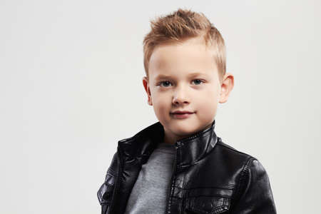 Fashionable child in leather coat.stylish little boy with trendy haircutの写真素材