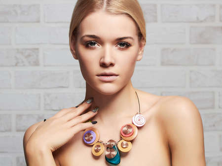 Fashion portrait of young beautiful woman posing over bricks wallの写真素材