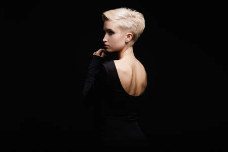 beautiful young woman in a black sexy dress.beauty blonde Girl with short haircut. fashion hairstyle