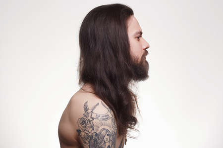 tattooed handsome bearded man with long hair.Brutal hipster boy with tattooの写真素材