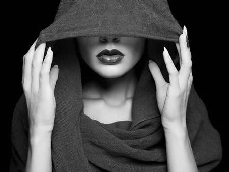 beautiful woman covers her face with scarf.beauty girl in hoodの写真素材