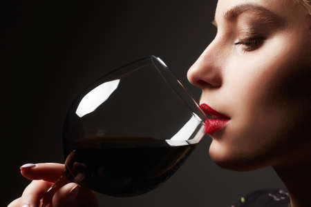 Beautiful young woman drinking wine.beauty girl with wineglassの写真素材