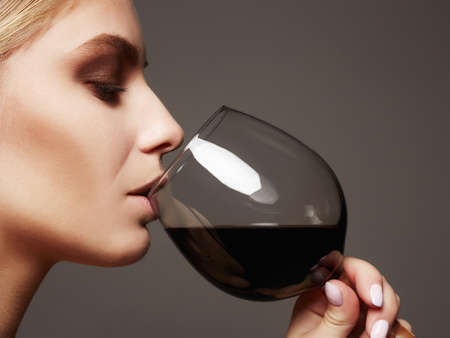 Beautiful young woman with red wine.beauty girl with wineglass. she enjoys the flavor of wine