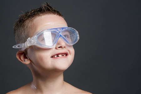 happy child in swimming goggles. smiling little boy in swimming mask. wet kidの写真素材