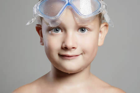 happy child in swimming goggles. smiling little boy in swimming mask. wet kidの写真素材