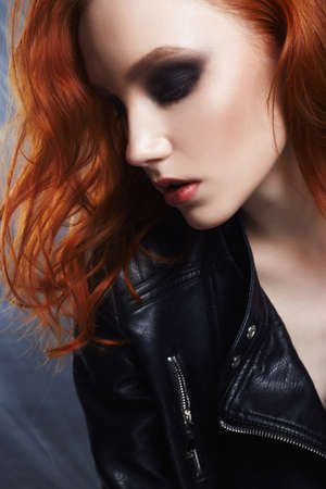 sexy Beautiful young woman portrait in leather coat. red hair girl with make-up