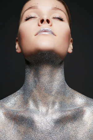 Silver Woman. Portrait of Beautiful Girl with Sparkles on Body and lips. Girl with Art Make-Upの写真素材