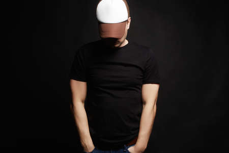 Young Man in Cap. Hipster Boy in hat over black Backgroundの写真素材