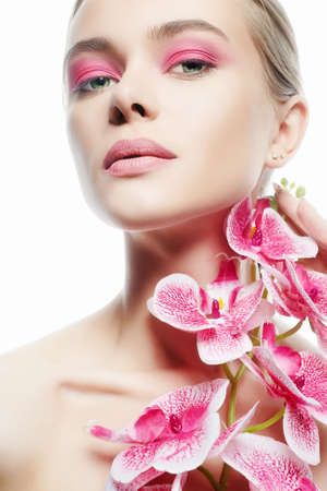 Beautiful young Woman with Make-up and Flower. Beauty Portrait of Girl with Orchid flower. Clean Skin Face, care.の写真素材