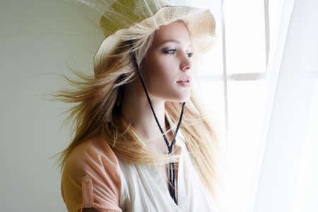 Sensual Country Woman in Hat Portrait. Cowgirl in Hat near the window. Beautiful Young Blondeの写真素材