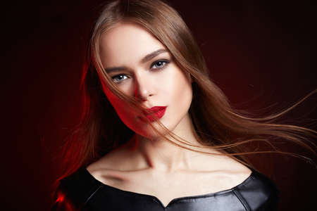 Beautiful young Woman with Flying healthy Hair. Beauty make-up, Model in Red lightの写真素材