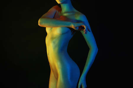 Nude Woman, Colorful bright lights posing in studio. sparkling shiny Rainbow Naked body of Girlの写真素材