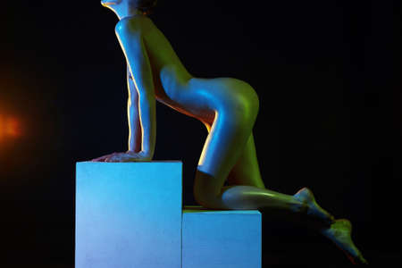 Nude Woman, Colorful bright lights posing in studio. sparkling shiny Naked body of Girl on cubeの写真素材