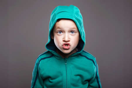 Funny boy in Hood. handsome funny kid. funny grimace emotion childの写真素材