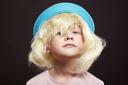 funny child in hat and wig. handsome funny kid. Little boyの写真素材