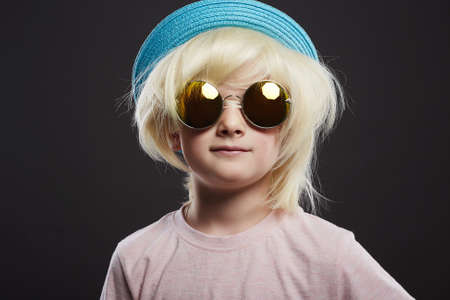 funny child with glasses, hat and wig. handsome funny kid. Little boyの写真素材