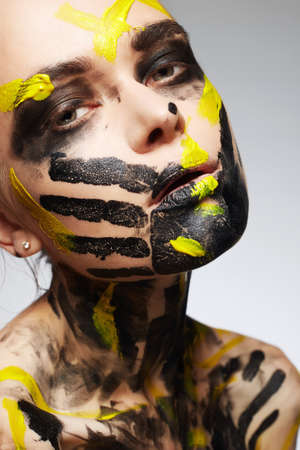 Painting on the face. beautiful woman in paint on face and Body. Color close-up portrait of Girl in Paintの写真素材