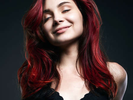 Happy Girl. beautiful Smiling young woman, red hair coloring. flying hairの写真素材