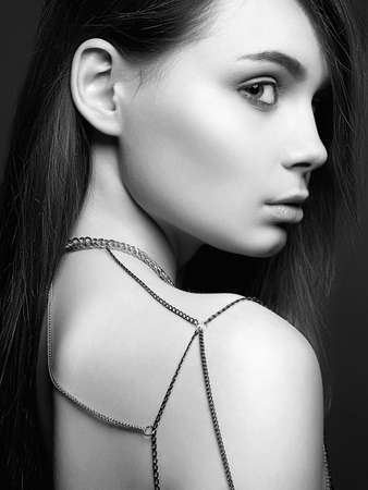 Pretty Girl with chain necklace on the shoulder. Beautiful sexy Young woman. Black and white portraitの写真素材