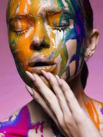 Color portrait of Girl in Paint. liquid paint flowing over a beautiful face and Body. Colorsの写真素材